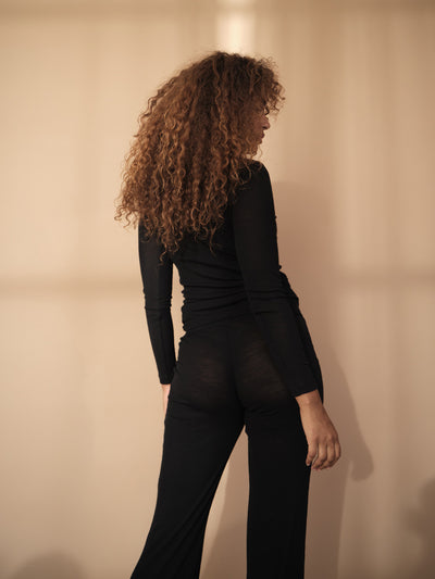 Female wearing our Amalie Long Sleeve Wool Top. Seen from the back.