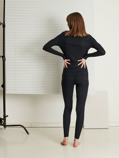 Female wearing our Celine Long Sleeve Top Black. Seen from the back.
